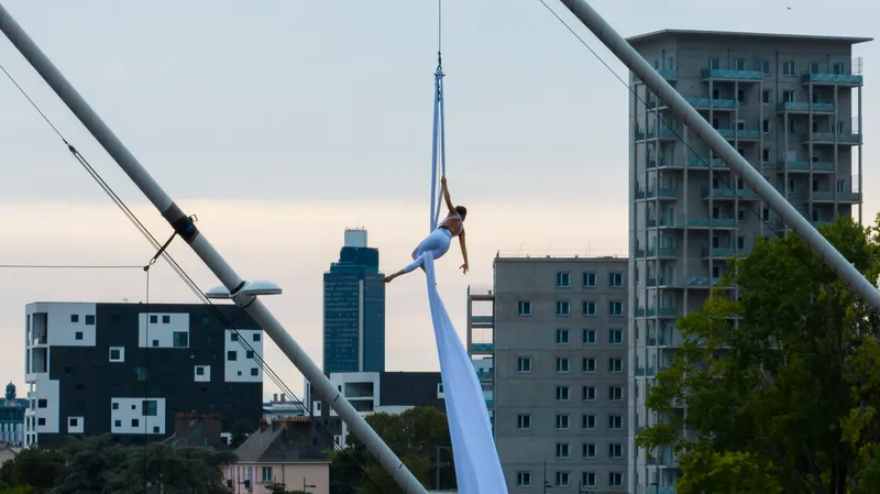 Aérienne au tissu suspendue au pylône du pont Éric Tabarly, la ville de Nantes en contrebas