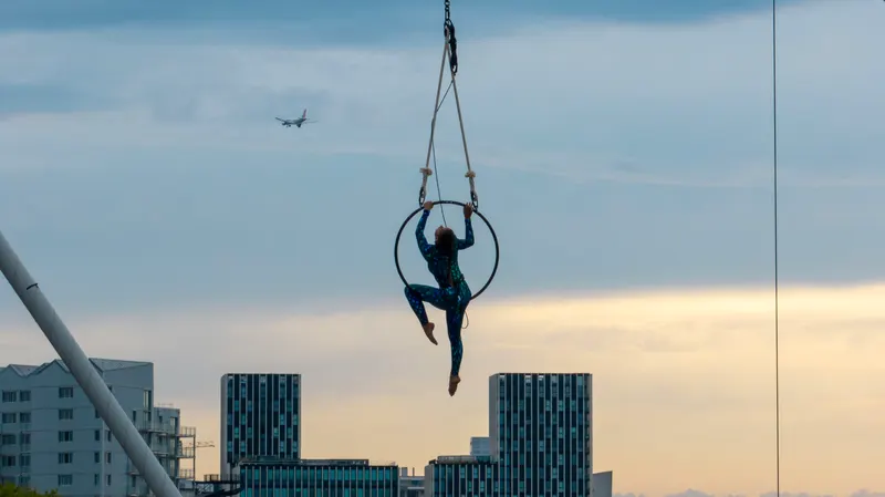 Silhouette au cerceau aérien contre le ciel, un avion passe au loin