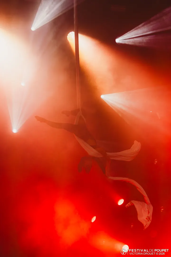 Artiste sous un faisceau de lumière dans un rouge dramatique